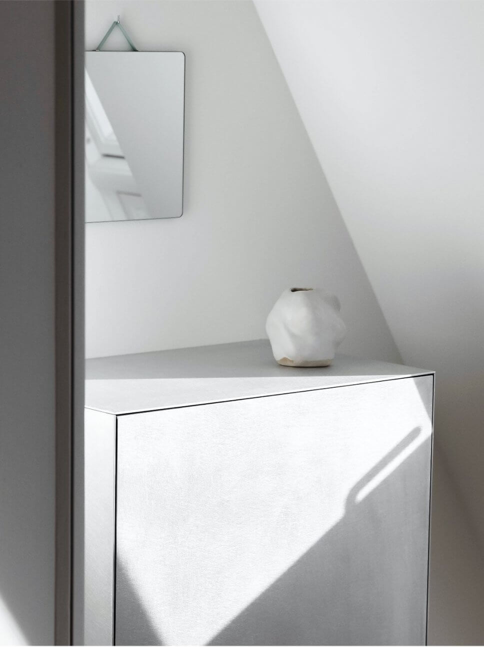 Kleiner Spiegel hängt über modernem Schrank