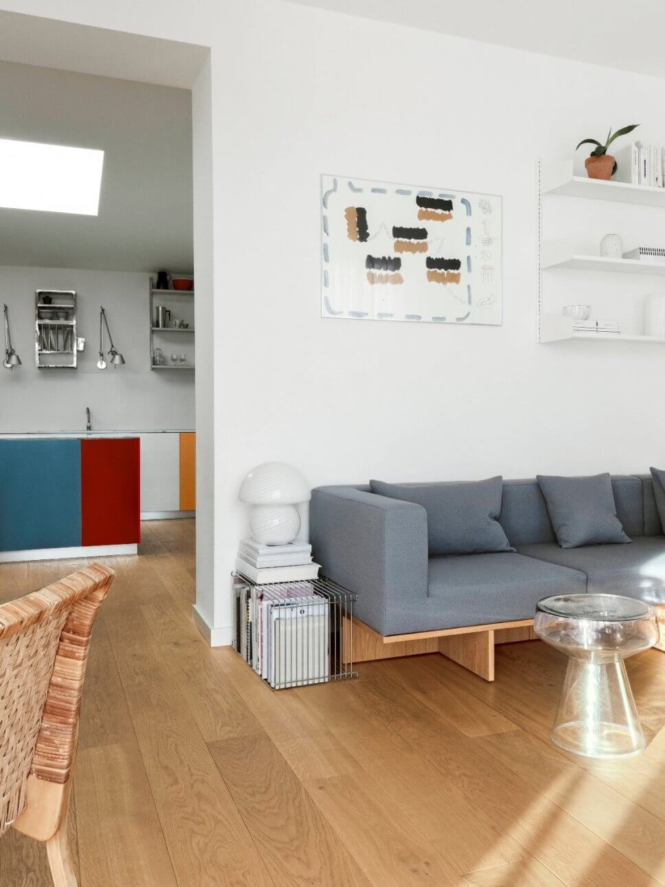 Modernes Wohnzimmer mit Sofa, Coffeetable und Blick in die Küche