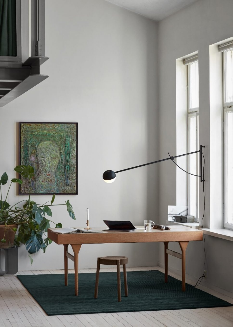 Moderne Wandleuchte hängt über Schreibtisch