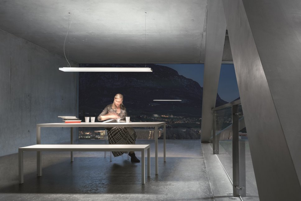 Moderne Pendelleuchte hängt über Schreibtisch