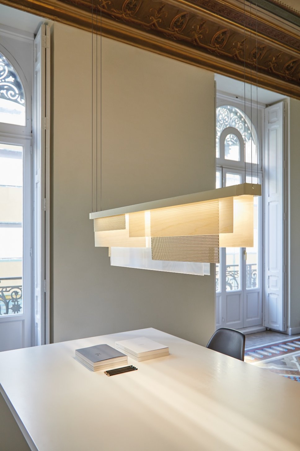 Moderne Pendelleuchte hängt über Schreibtisch