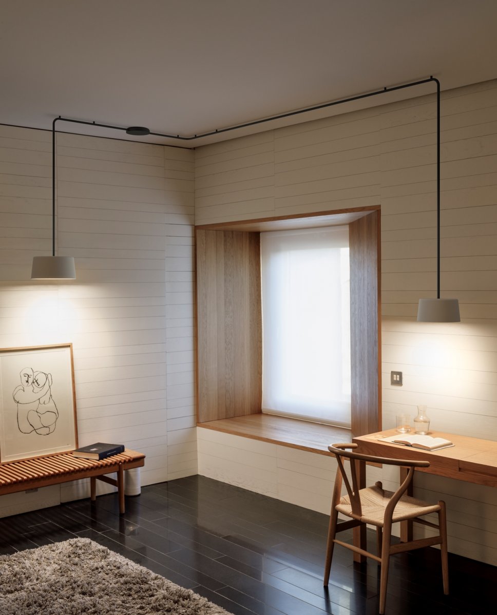 Moderne Pendelleuchte hängt über Schreibtisch