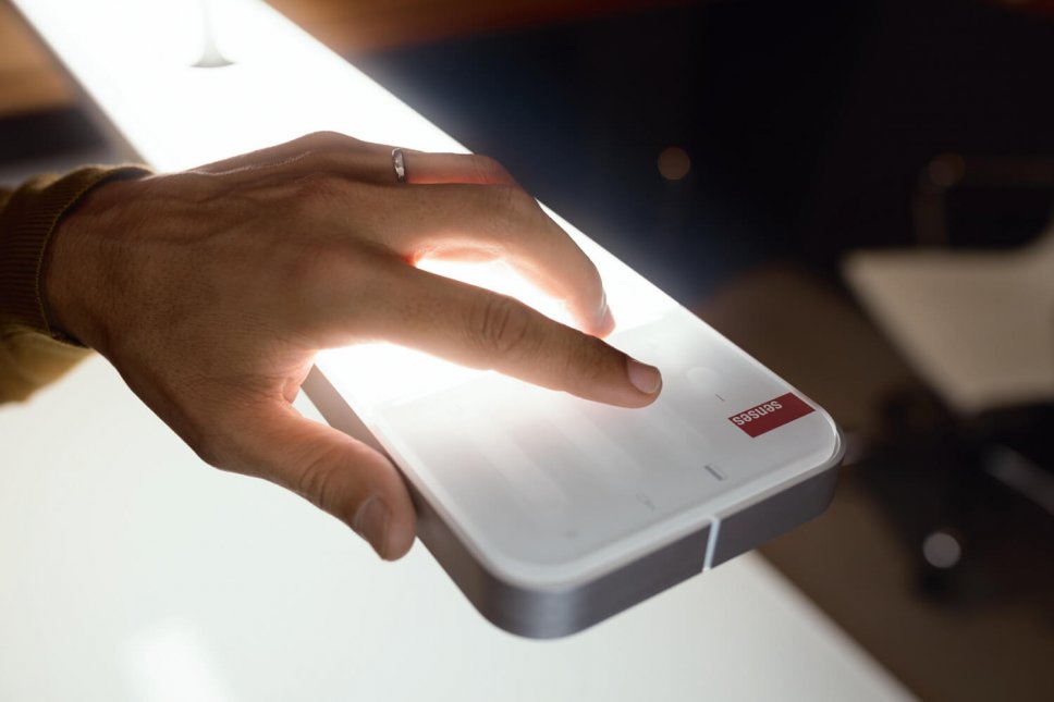 Hand berührt Kopf einer Hängeleuchte zum Einschalten