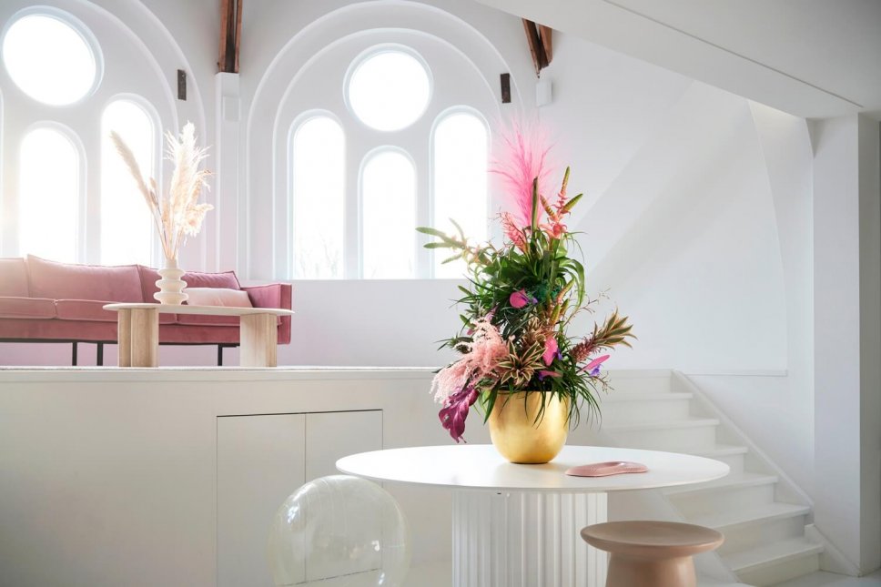 Moderner Wohnraum mit goldener Vasen, gefüllt mit Bromelie