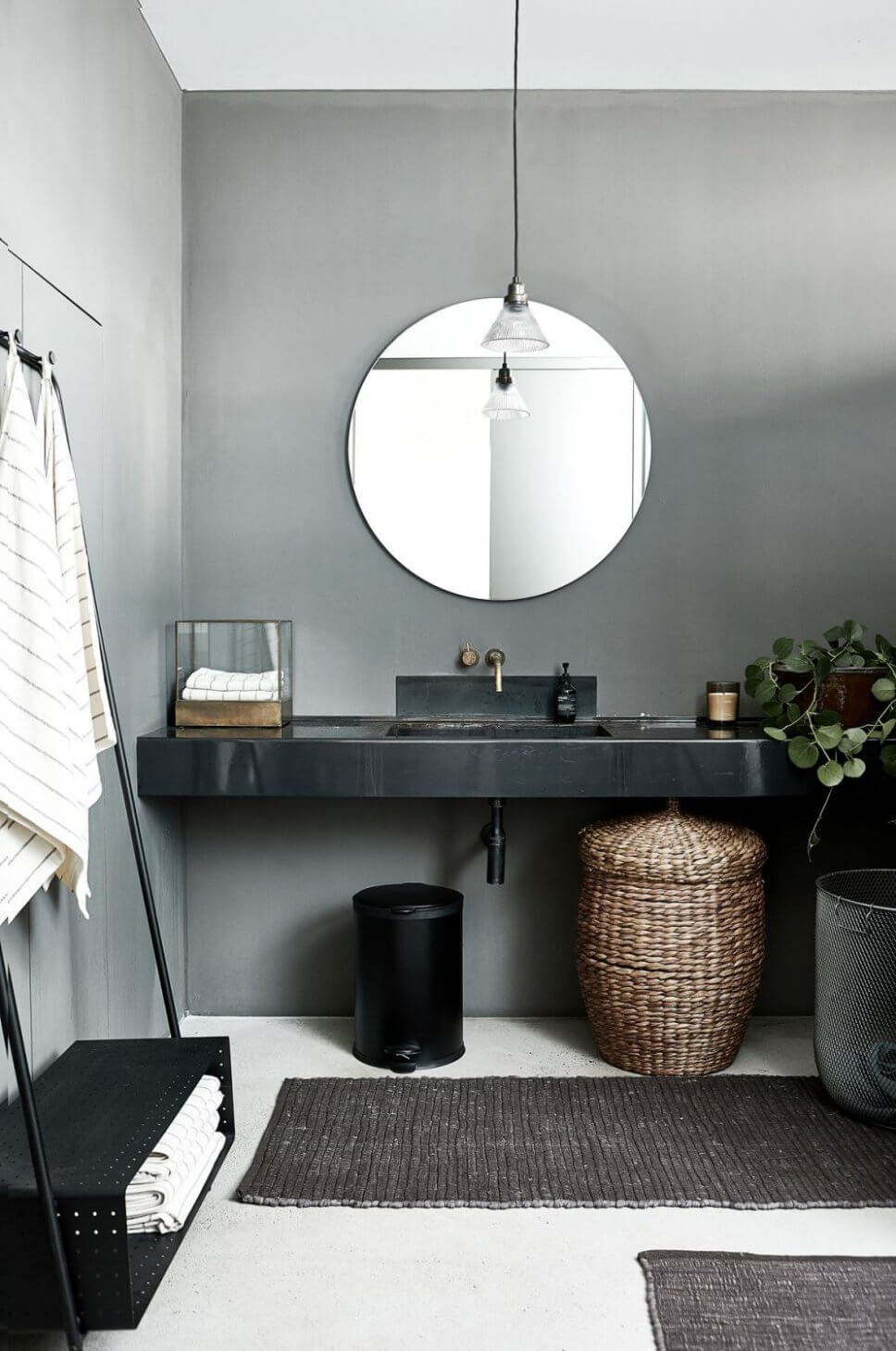 Schwarzer Waschtisch mit rundem Spiegel darüber