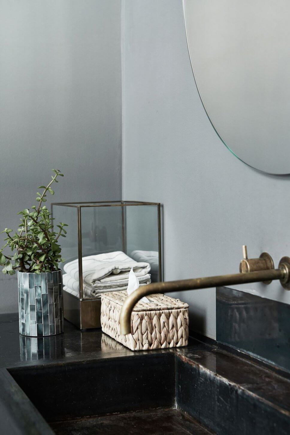 Glasvitrine mit Handtuch und Kosmetiktuchbox aus Korb auf Waschtisch