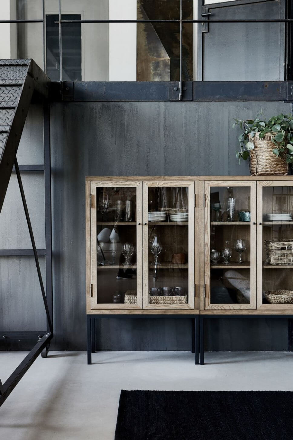 Holzvitrine mit Geschirr im Industrieloft