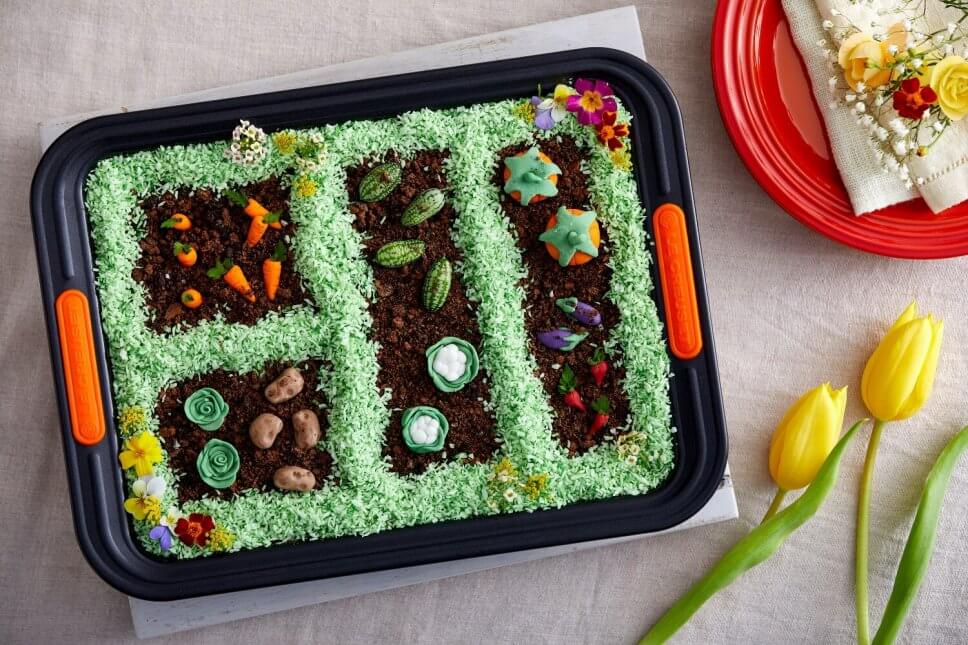 Osterkuchen in der Backform mit grünem Kokosgras und Fondantgemüse