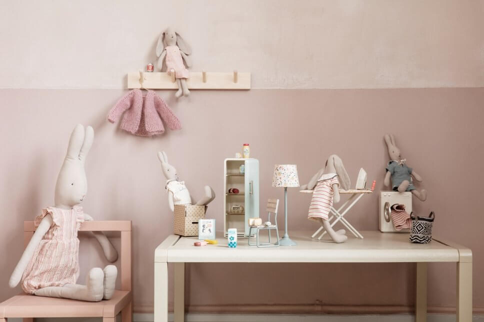 Osterhasen aus Stoff auf Tisch mit Puppenhausmöbeln