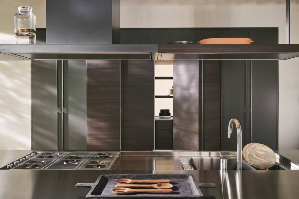 Moderne offene Küche mit Kochbereich hinter geöffneten Falttüren und Kücheninsel