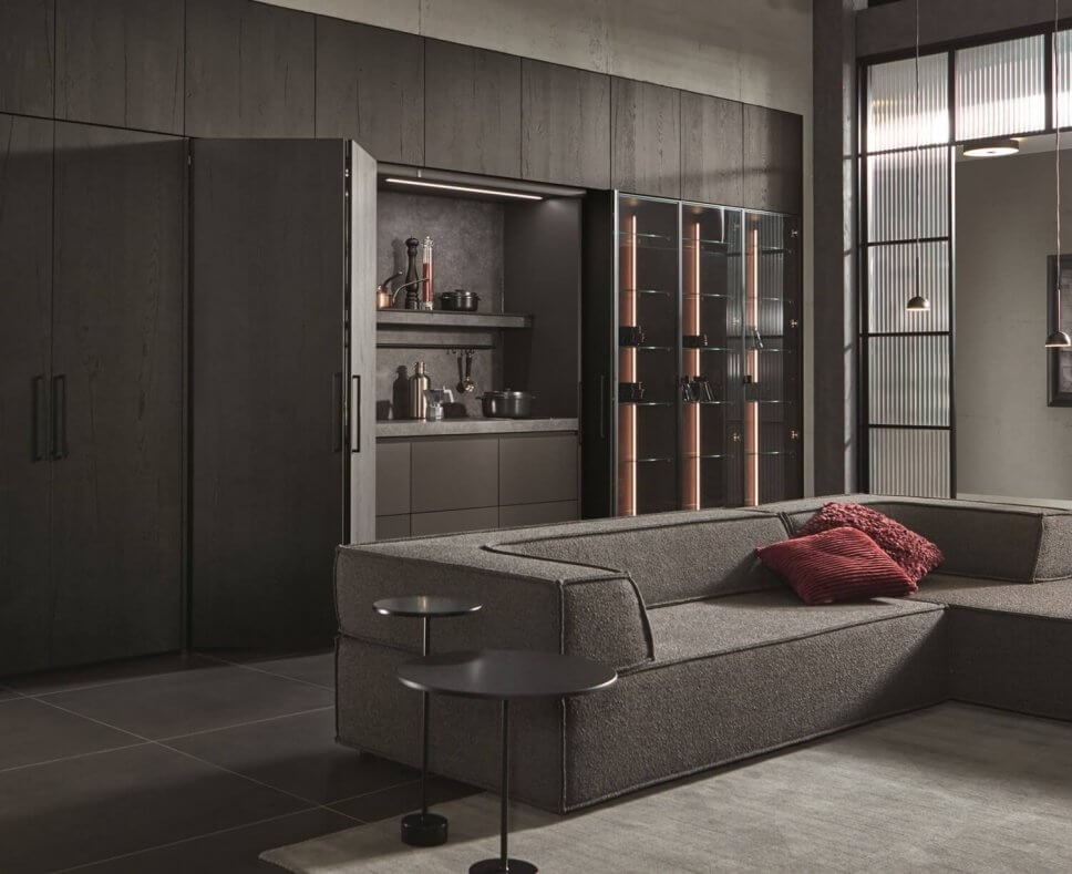 Moderne offene Küche mit Kochbereich hinter geöffneten Falttüren, Vitrine und Sofa