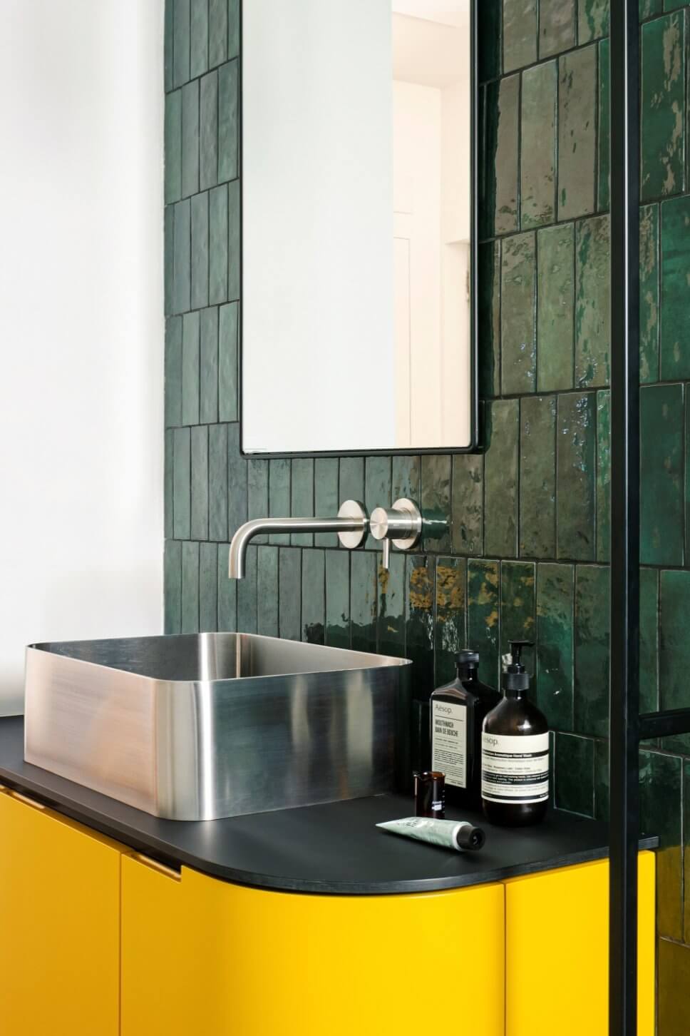 Großes Modernes Duschbad mit Kassettenfronten, gelben Schränken, offener Dusche, Wandtoilette, grünen Fliesen, Keramikfliesen, grüner Wandfarbe, Marmorboden, Aufsatzwaschbecken, Laminat-Waschtisch, grauem Boden und schwarzer Waschtischplatte in Mailand