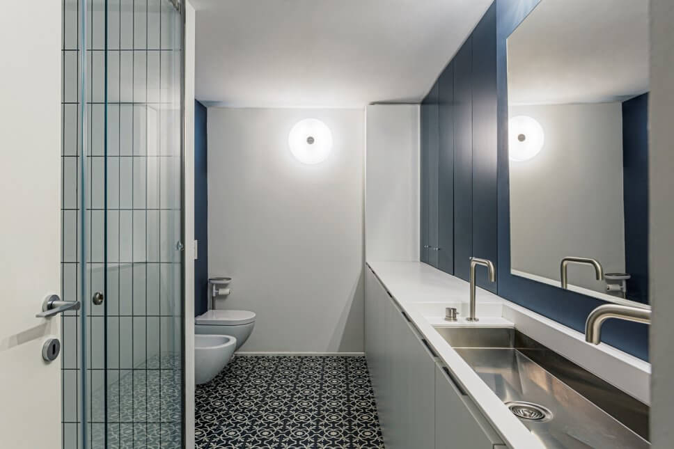 Großes Modernes Duschbad mit Kassettenfronten, weißen Schränken, offener Dusche, Wandtoilette, weißen Fliesen, Porzellanfliesen, blauer Wandfarbe, Zementfliesen, Unterbauwaschbecken, blauem Boden und weißer Waschtischplatte in Mailand