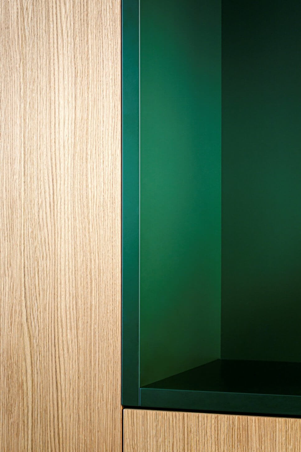 Detail einer Einbauküche aus hellem Holz und grünem Lack