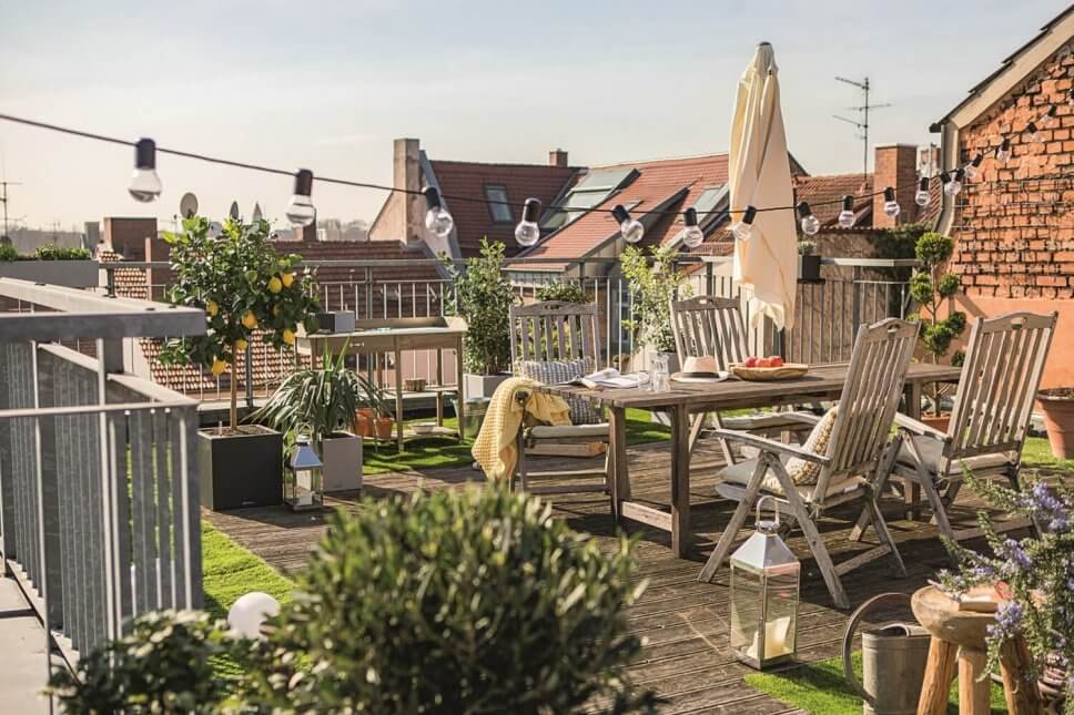 Üppig mit Kübelpflanzen und Balkonkasten bepflanzten Balkon