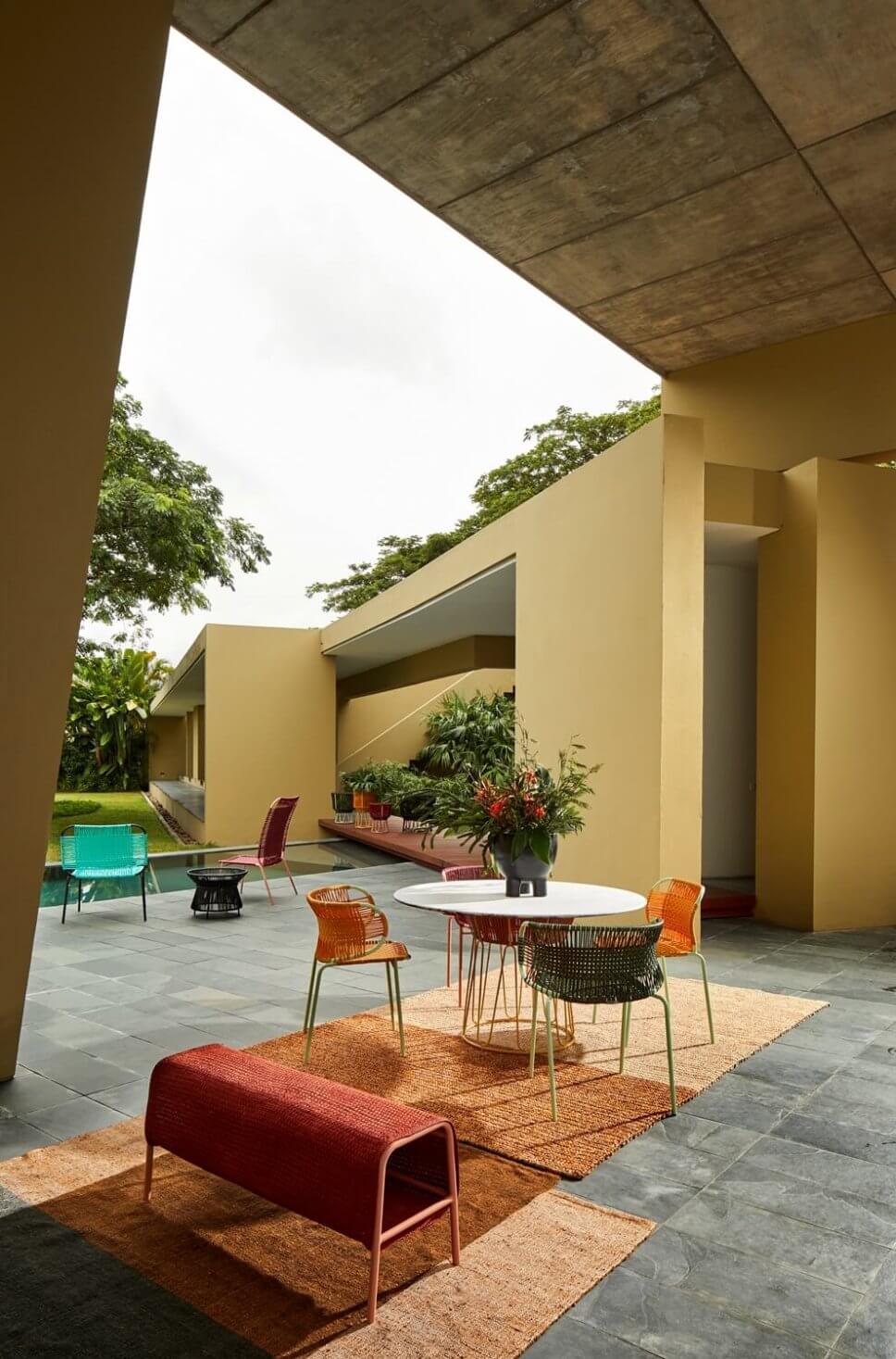 Terrasse mit Teppichen, Bank und Sesseln aus Geflecht in einer kolumbianischen Casa