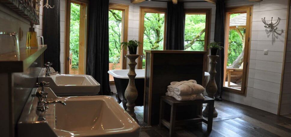 Badezimmer mit zwei Waschbecken und einer Badewanne in einem geräumigen Baumhaus