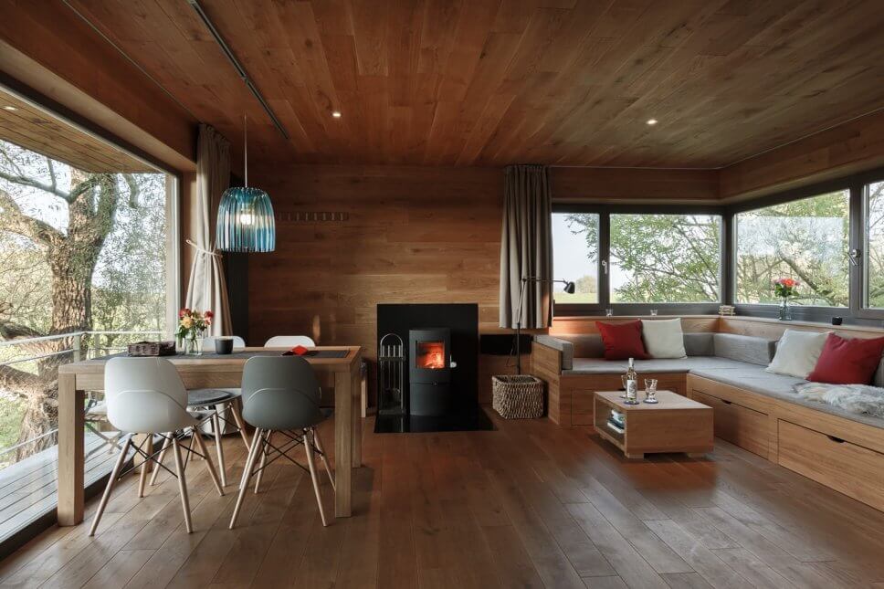 Esstisch, Kamin und Sofa in einem geräumigen Baumhaus