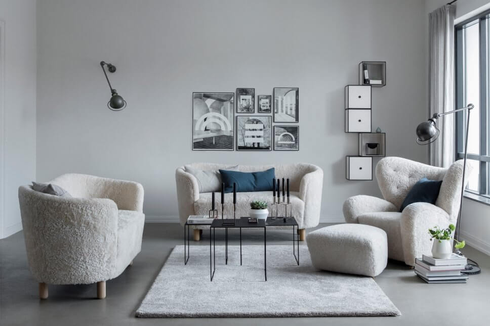 Modernes Wohnzimmer mit Schaffell bezogenen Sofas und Ohrensessel