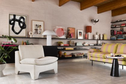 Mit Boucléstoff bezogener Sessel und gestreiftes Sofa in modernem Wohnzimmer