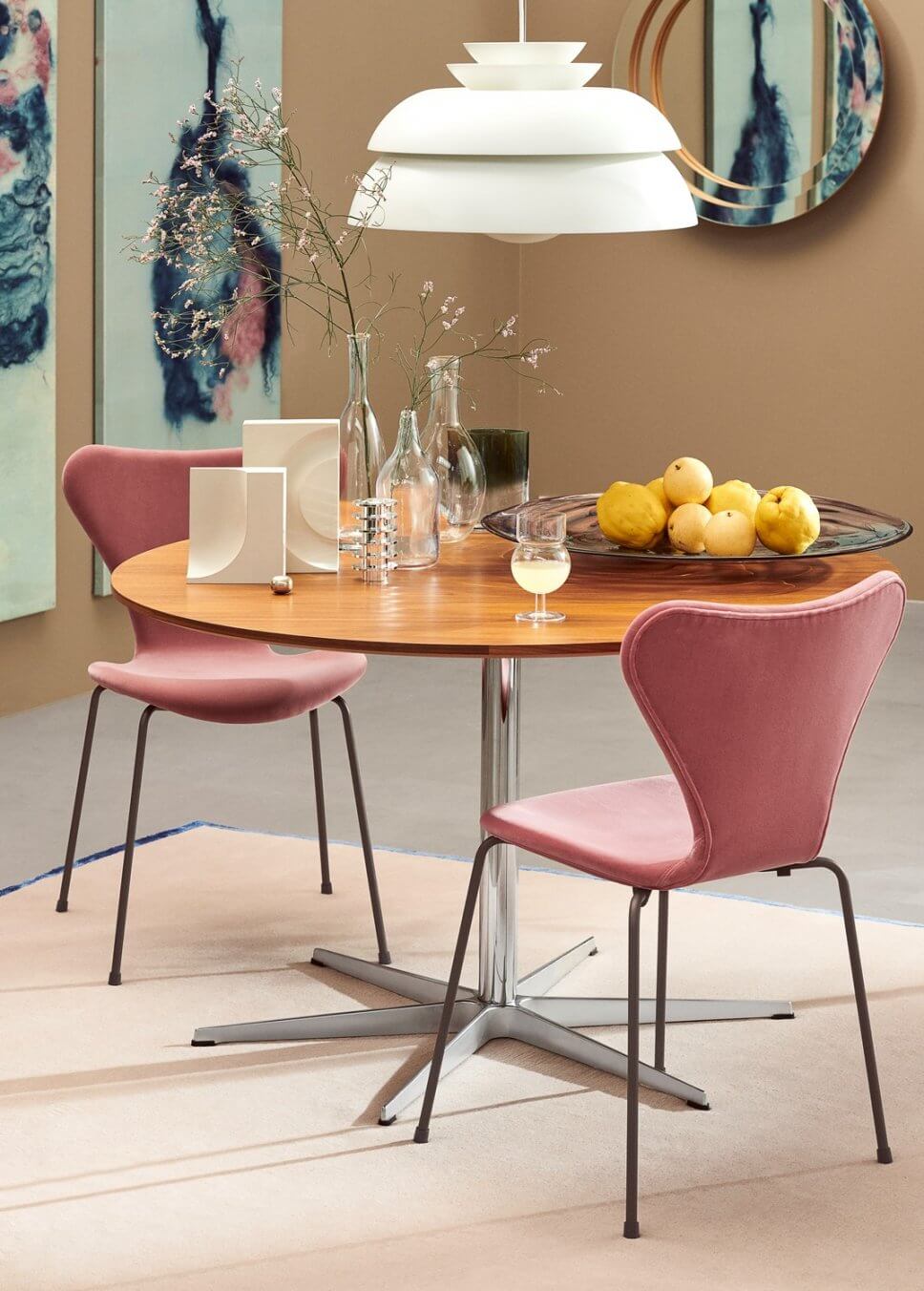 Zwei gepolsterte Stühle stehen an einem runden Esstisch