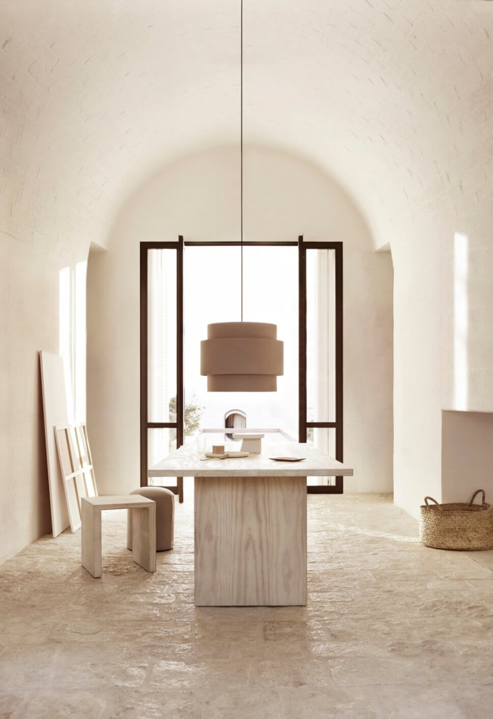 Modernes Esszimmer mit Tisch, Hockern und Hängelampe in mediterranem Haus mit steinerner Gewölbedecke