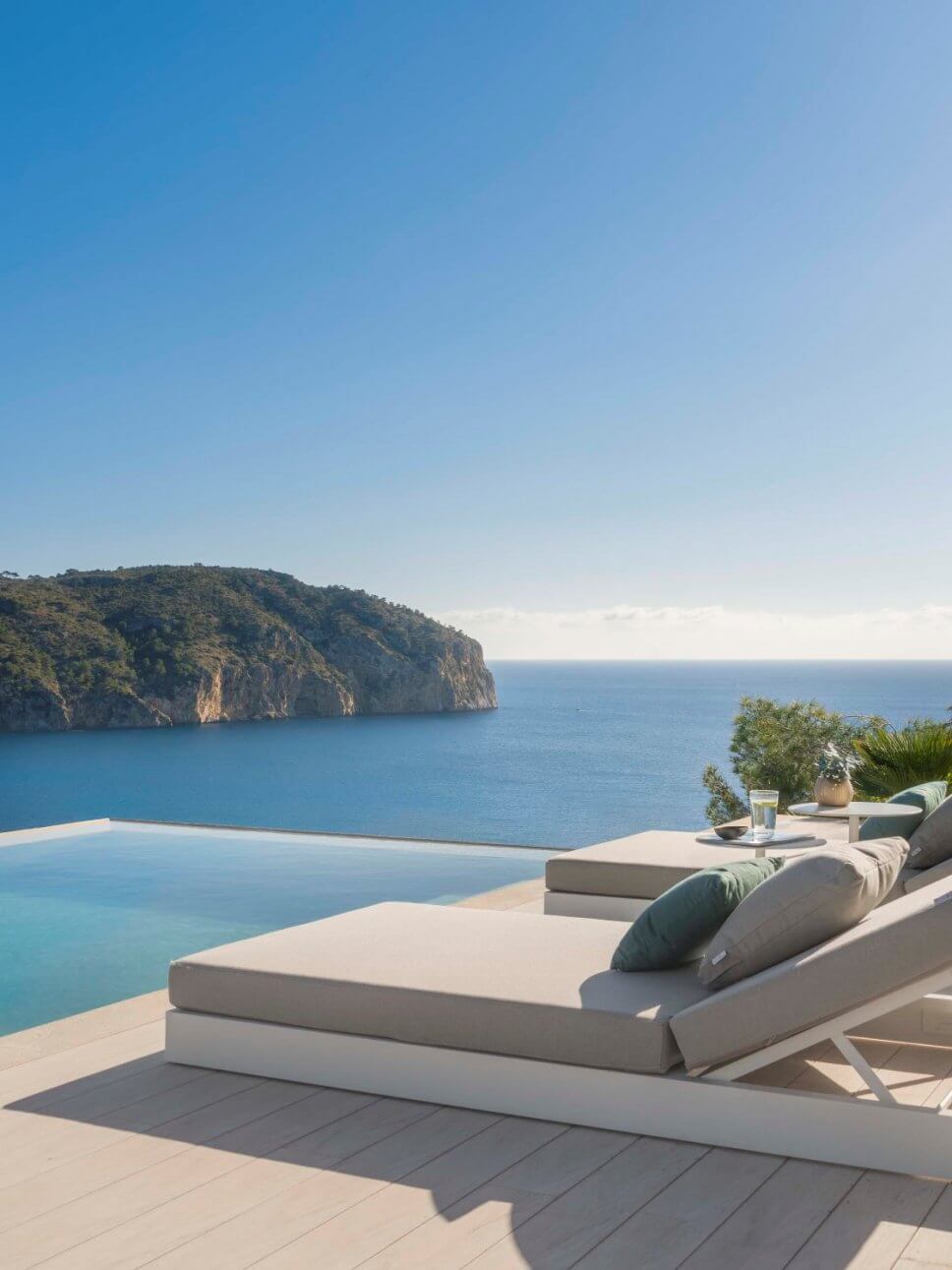 Terrasse mit zwei Liegen in moderner Villa mit Blick aufs Meer