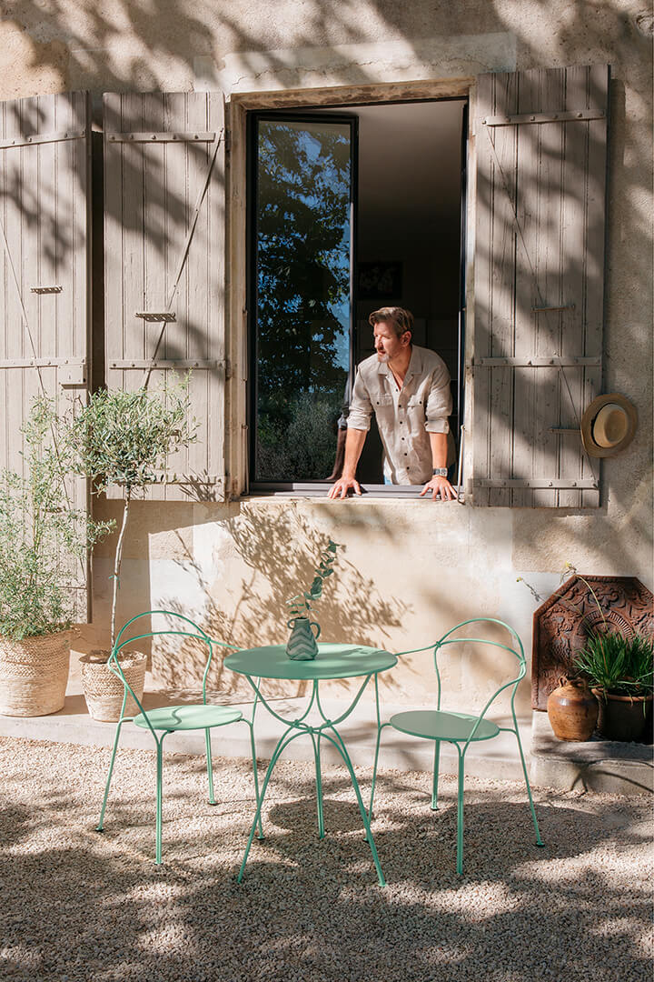 Moderne Gartenstühle stehen um einen Tisch auf Terrasse