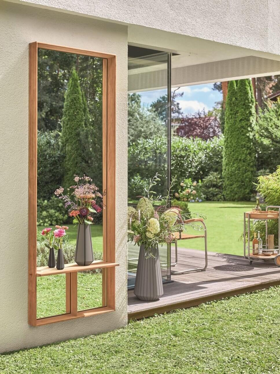 Wandspiegel hängt an Außenwand vor Terrasse