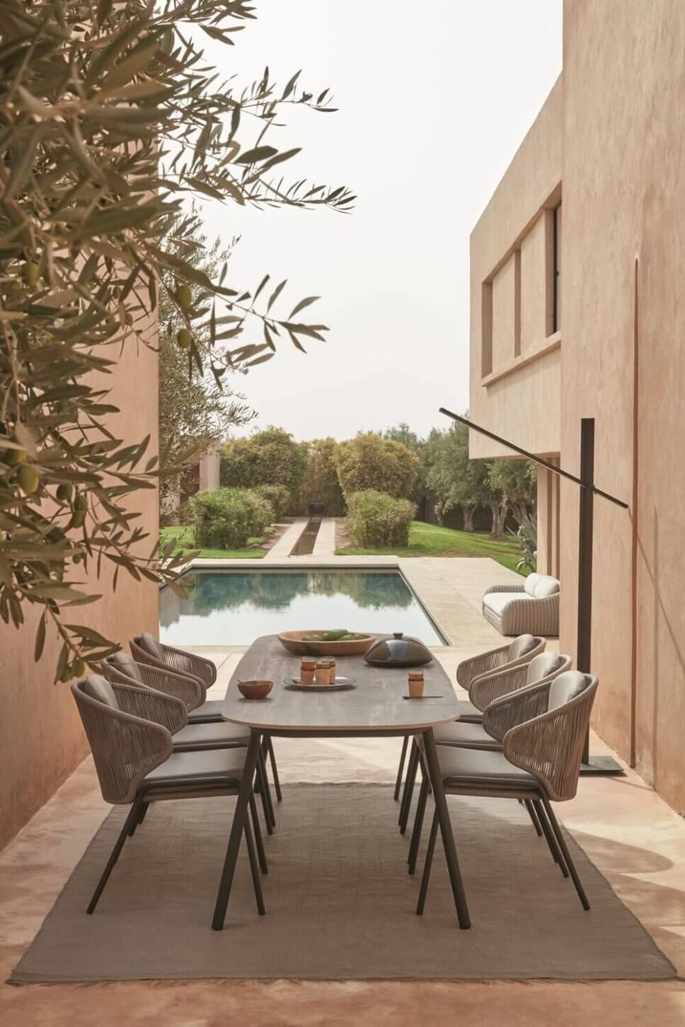 Moderne Gartenstühle stehen um einen Tisch auf Terrasse