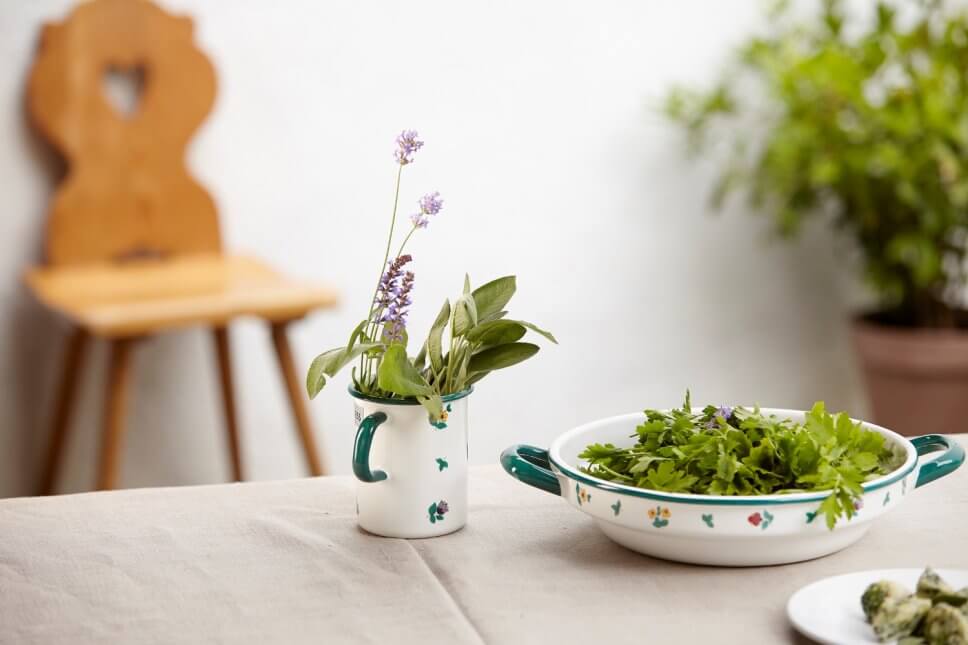 Emaillegeschirr mit Blümchendekor, gefüllt mir Küchenkräutern