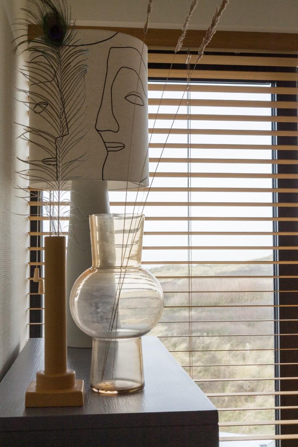 Zwei Vasen stehen vor einer modernen Tischleuchte
