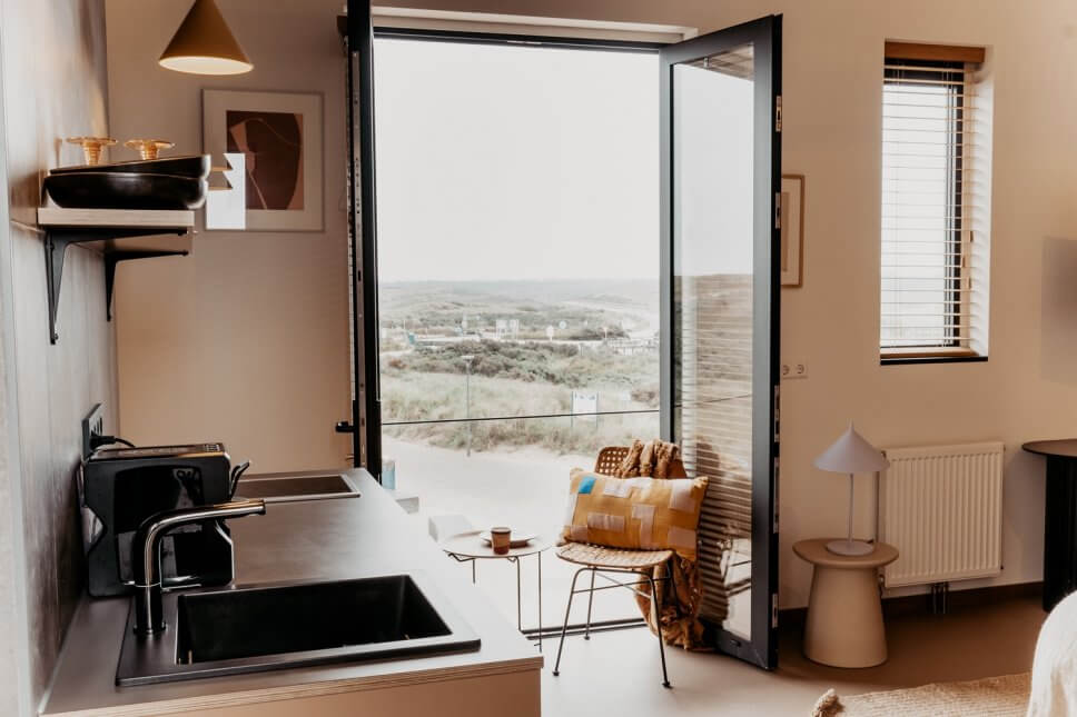 Modern eingerichteter Wohnraum mit Küchenzeile im Vordergrund