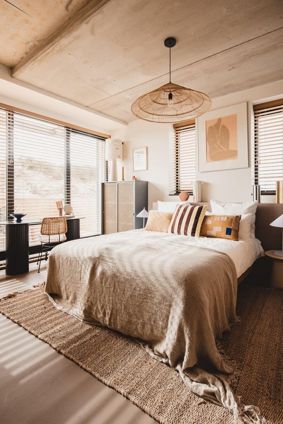 Modern eingerichtetes Schlafzimmer mit vielen Kissen im Bett