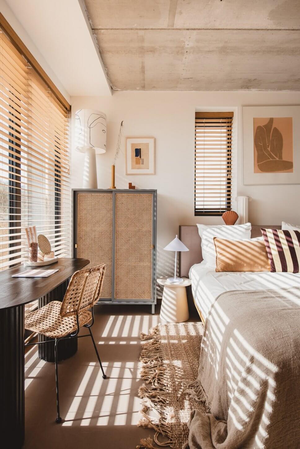 Modern eingerichtetes Schlafzimmer mit vielen Kissen im Bett