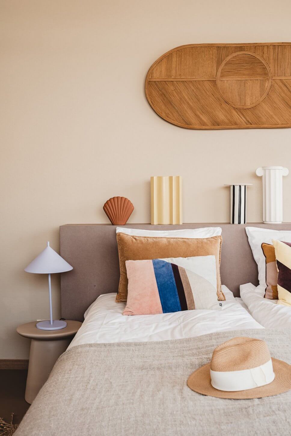 Modern eingerichtetes Schlafzimmer mit vielen Kissen im Bett