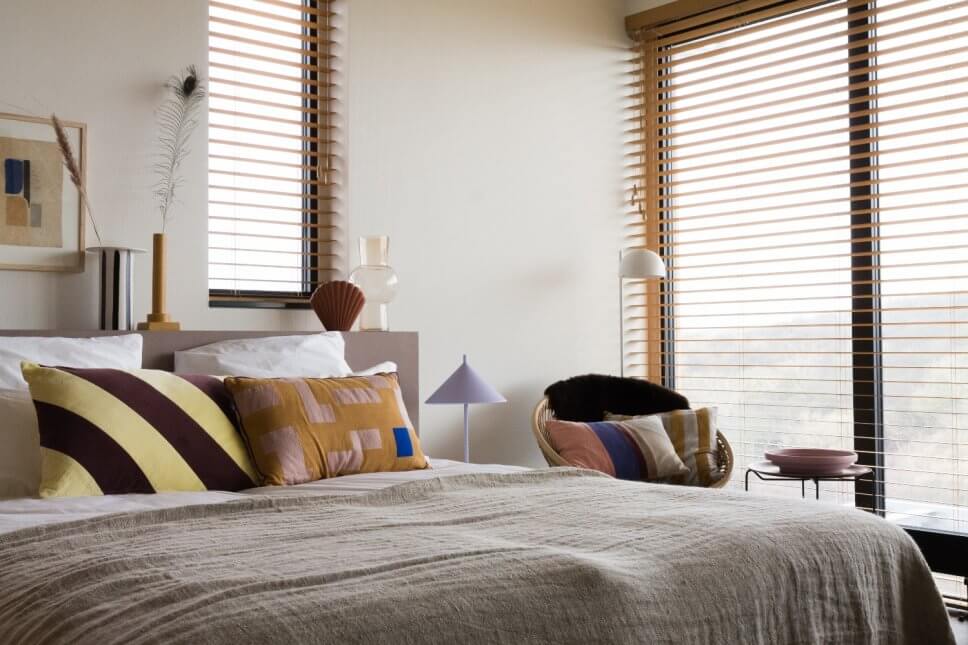 Modern eingerichtetes Schlafzimmer mit vielen Kissen im Bett