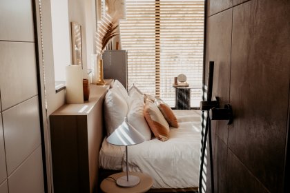 Modern eingerichtetes Schlafzimmer mit vielen Kissen im Bett