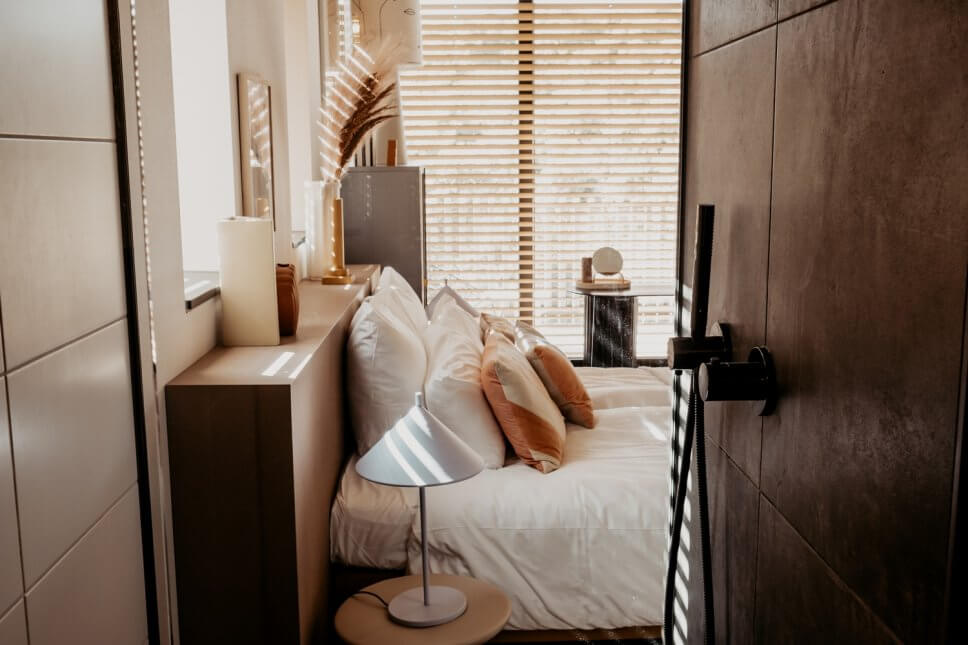 Modern eingerichtetes Schlafzimmer mit vielen Kissen im Bett