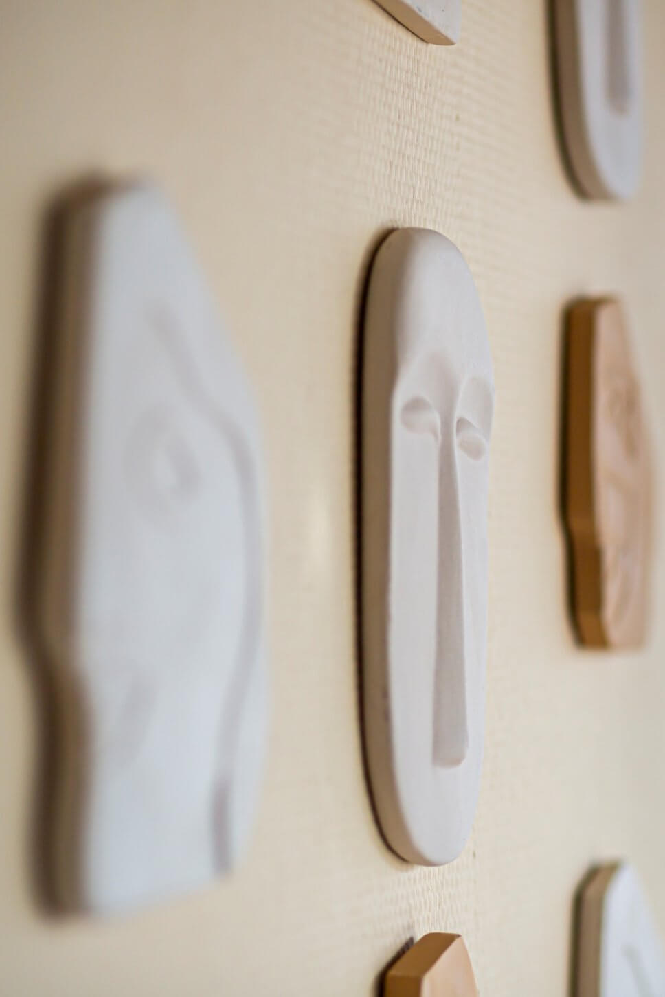 Sammlung der exotischer Steingut-Masken an einer Wand