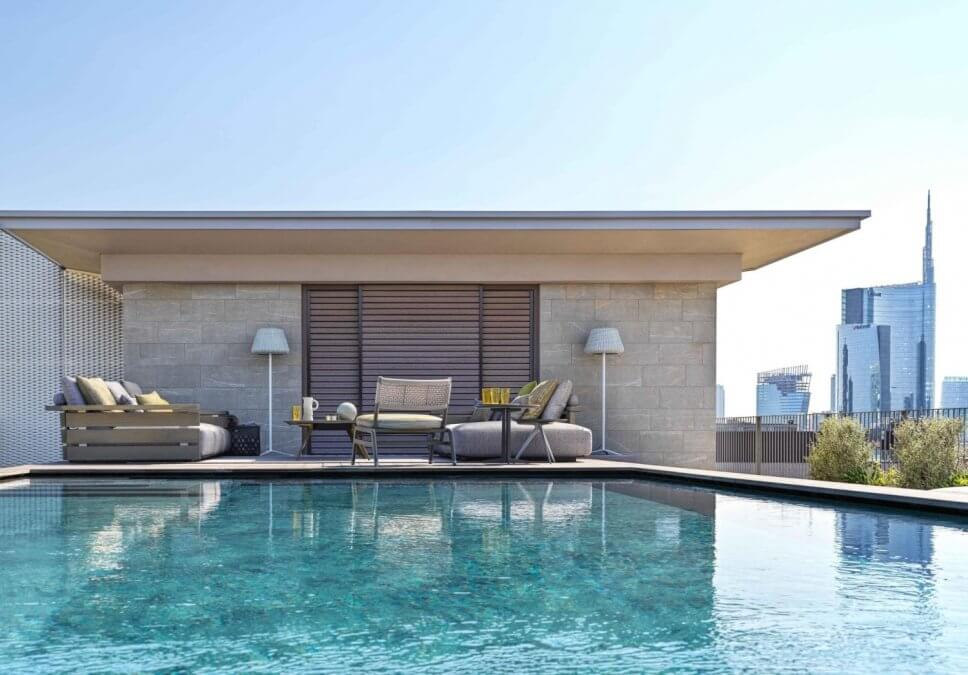 Modernes Gartensofa auf Terrasse neben Pool