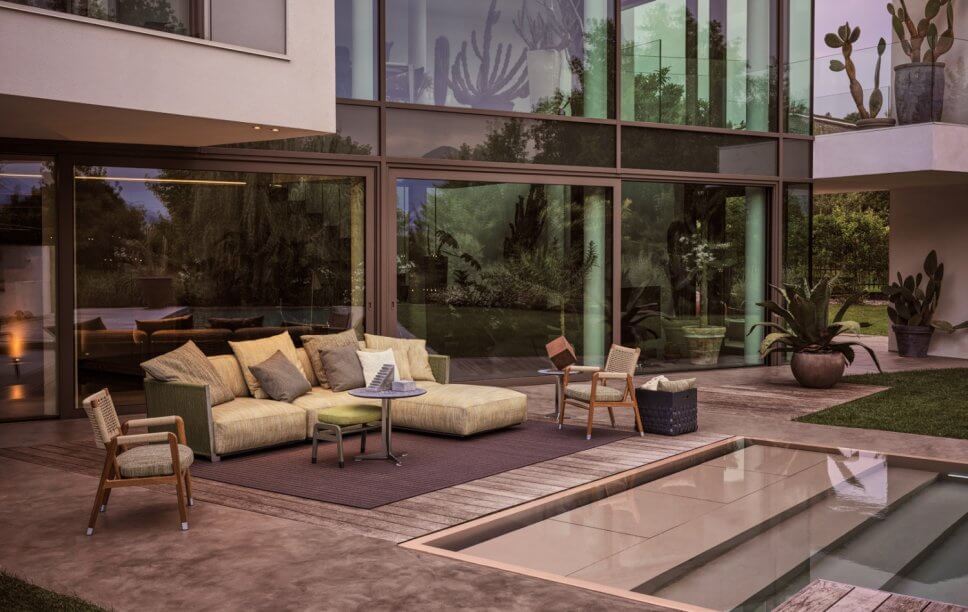 Modernes Gartensofa auf Terrasse neben Pool