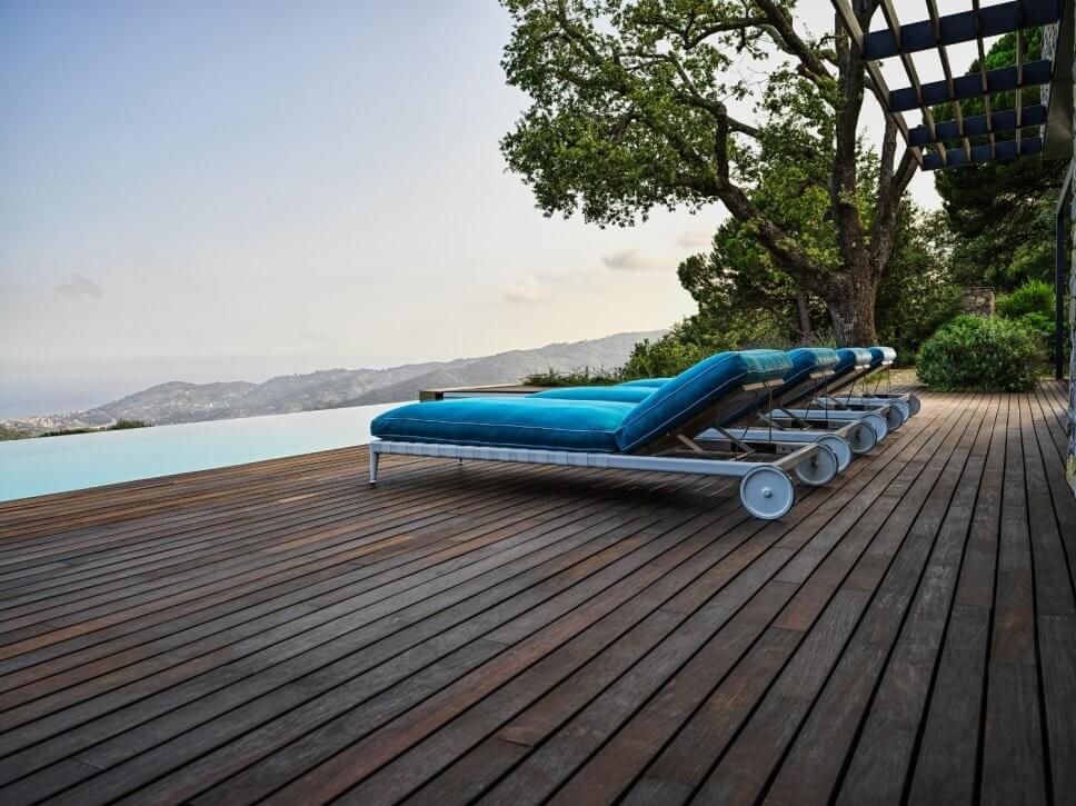 Modernes Sonnenliegen auf Terrasse neben Pool