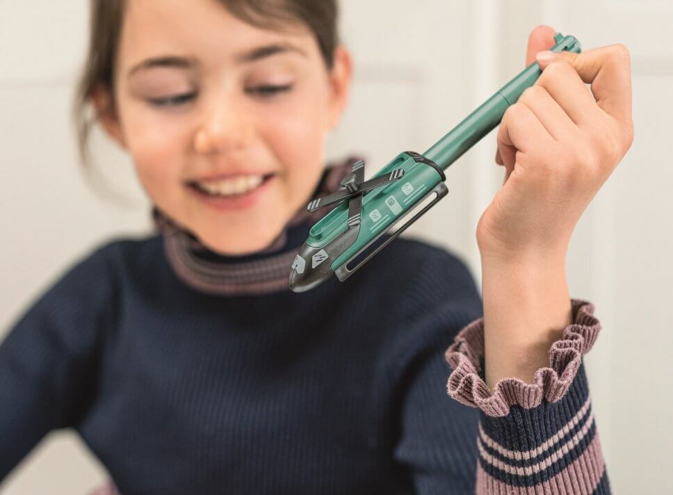 Mädchen hält Stift im Hibschrauberdesign