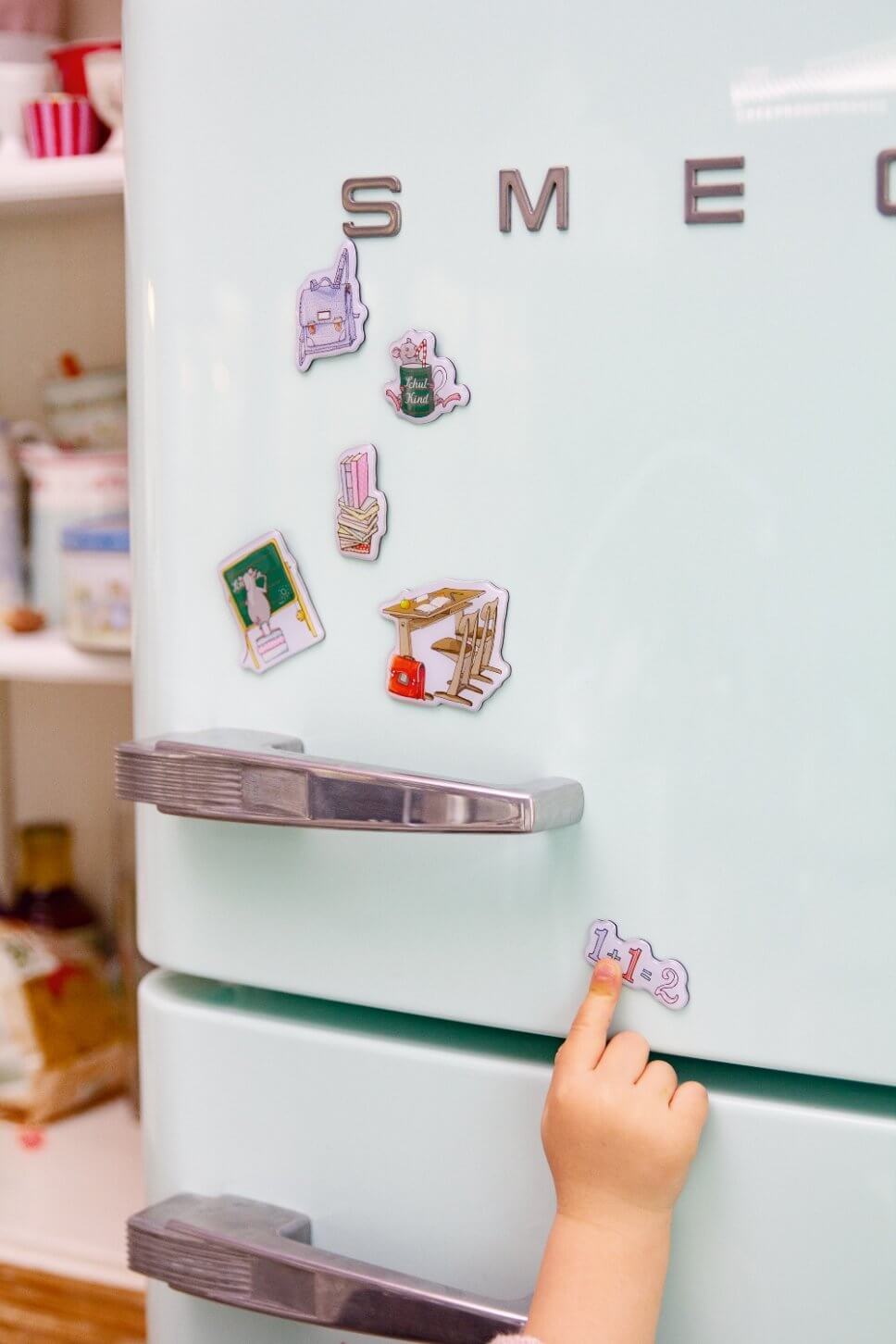 Bunte Magneten mit Schulmotiven am Kühlschrank