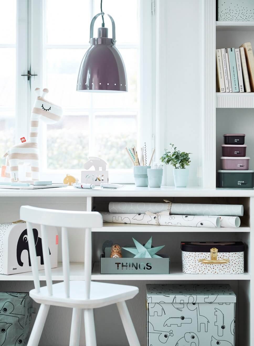 Schreibtisch mit Schachteln, Heften und Stiften