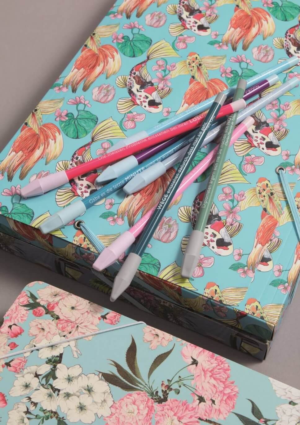 Bunte Notizhefte und Stifte