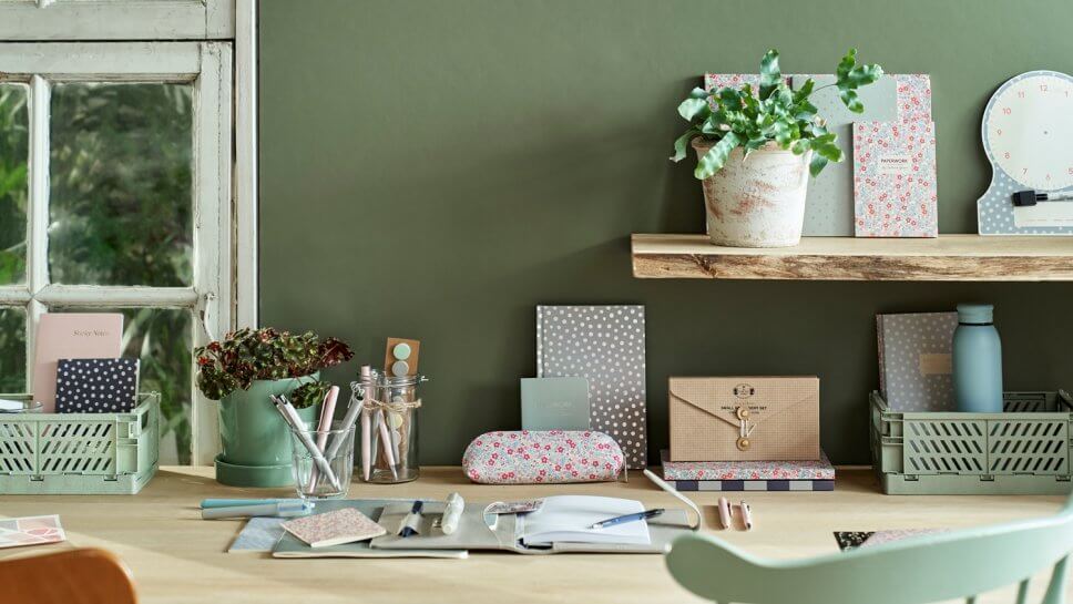 Schreibtisch mit bunten Heften und Stiften