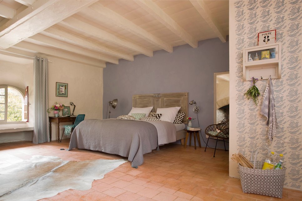 Farbenfroh und nostalgisch eingerichtetes Schlafzimmer in altem französischen Landhaus