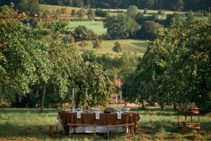 Herbstlich gedeckter Tisch auf Wiese unter Apfelbäumen